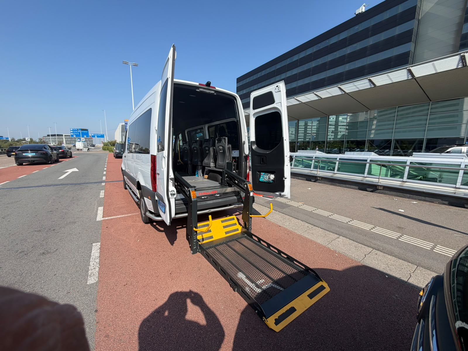 Rolstoelbus met uitgeklapte laadklep, klaar om in te stappen